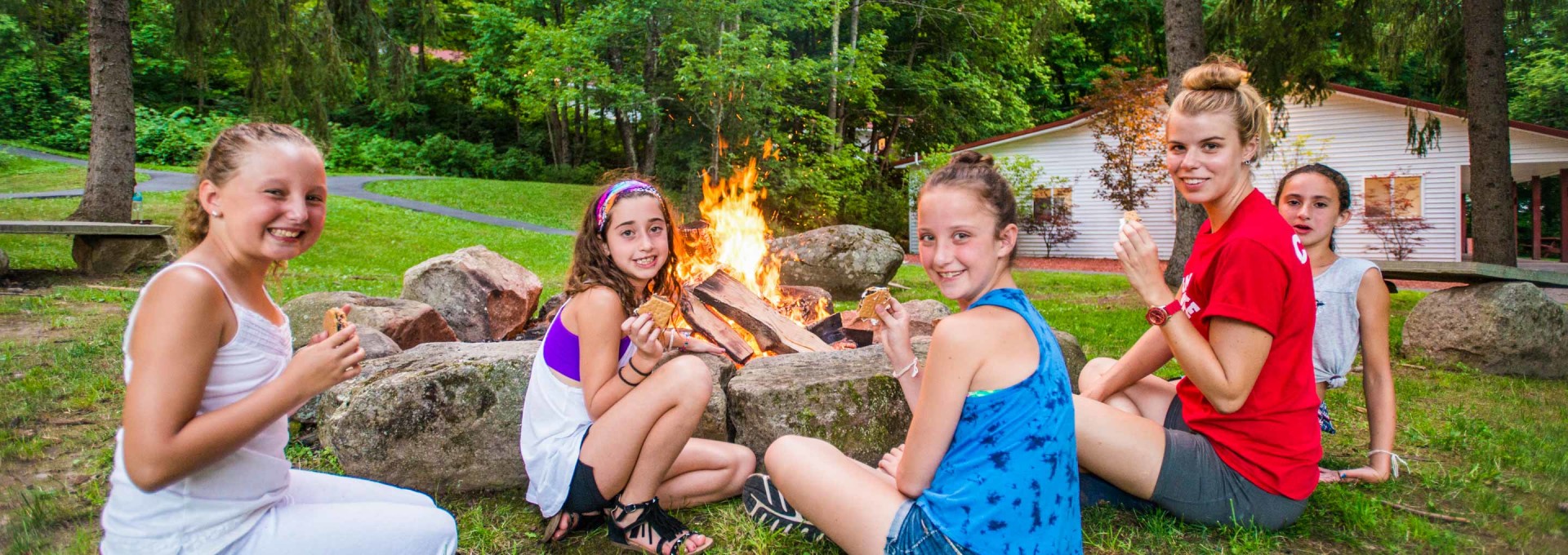 Campers enjoying s'mores by the bonfire